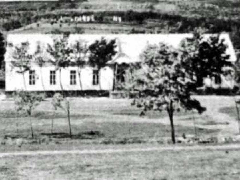 Bethaus links, Schule rechts, vorn Glockenturm, oben Friedhofsgrabsteine