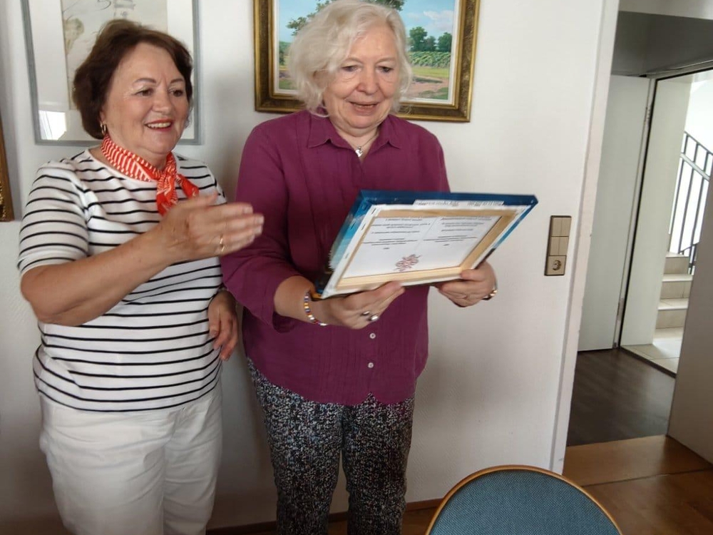 Liubov Klim überreicht ein Gastgeschenk  zum Jubiläum des bessarabiendeutschen  Vereins (s. Header)