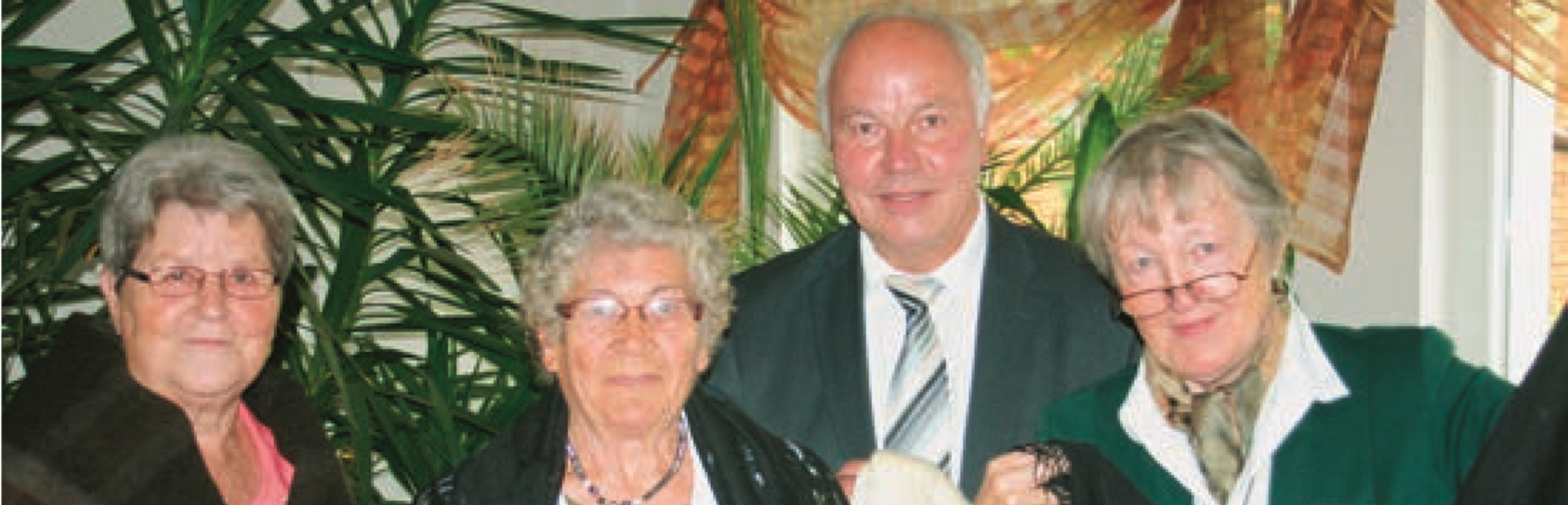 &Uuml;bergabe von bessarabischen Kleidungsst&uuml;- cken an den Bessarabiendeutschen Verein durch Frau Jortzig. V.l.n.r.: Wilma Gaier (verantwortlich f&uuml;r die Veranstaltung vor Ort in M&ouml;ckern), Frau Jortzig, Wolfgang Bunk (Moderation der Veranstaltung) und Erika Wiener (stellvertretende Bundesvor- sitzende, Organisation der Veranstaltung)