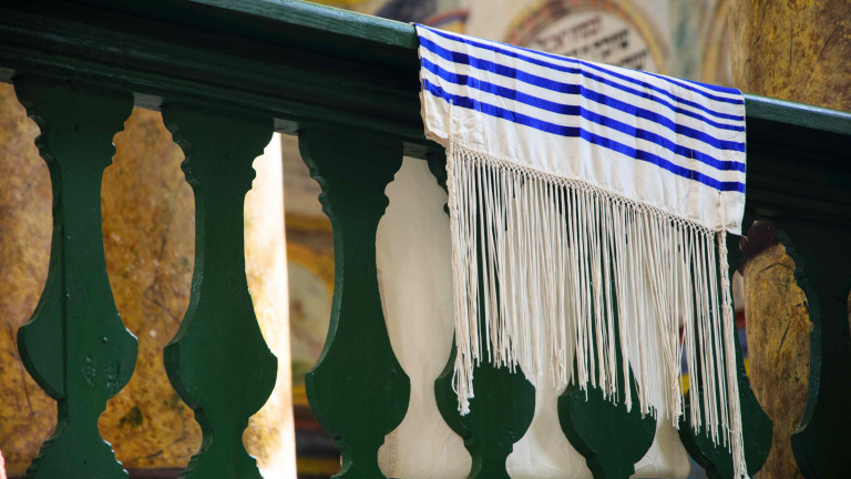 ein Tallit (j&uuml;discher Gebetsmantel) &uuml;ber dem Gel&auml;nder einer Synagoge