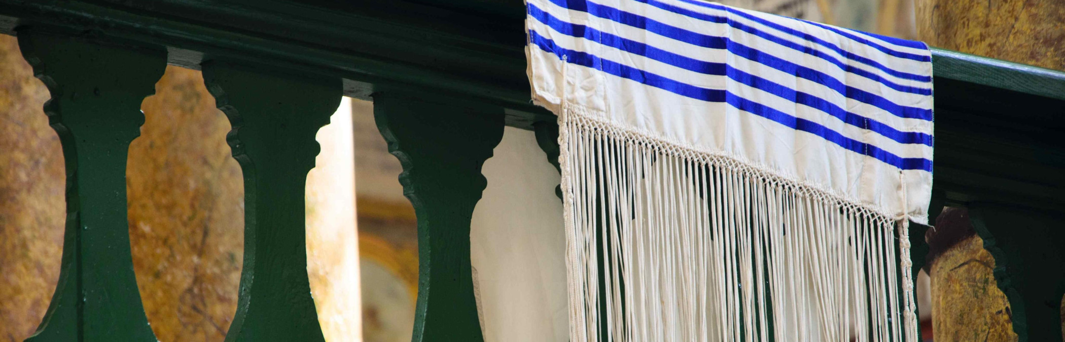 ein Tallit (j&uuml;discher Gebetsmantel) &uuml;ber dem Gel&auml;nder einer Synagoge